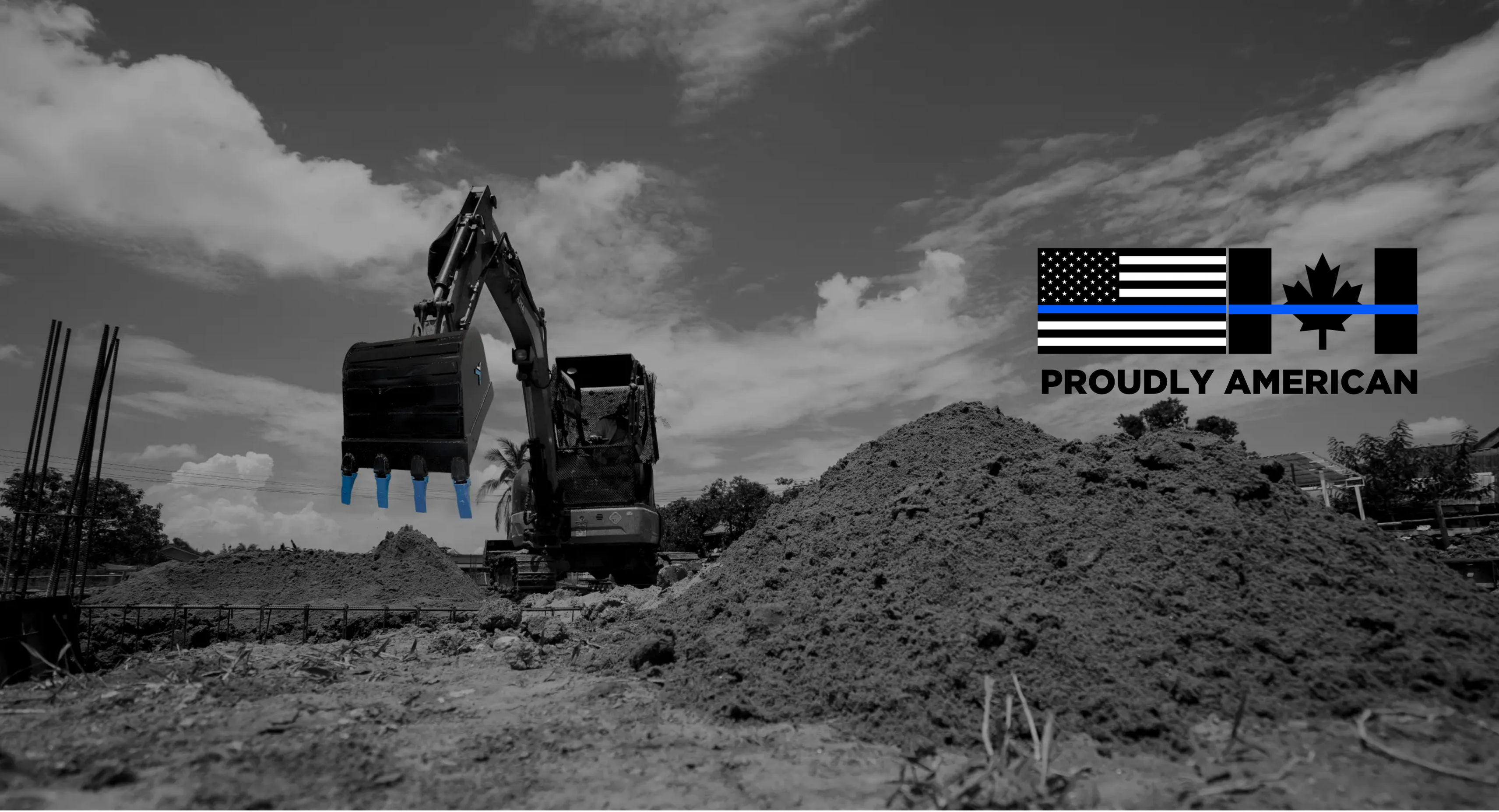 Excavator digging at a site with the American and Canadian flags