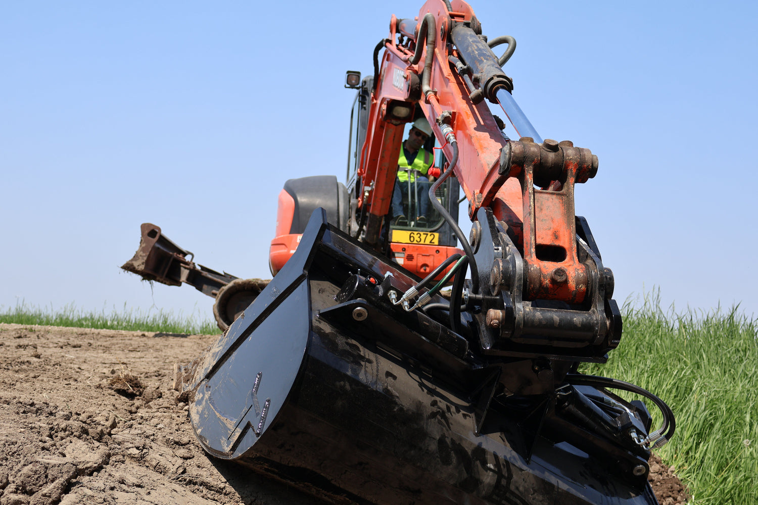 Excavator on a construction site with a clear blue sky